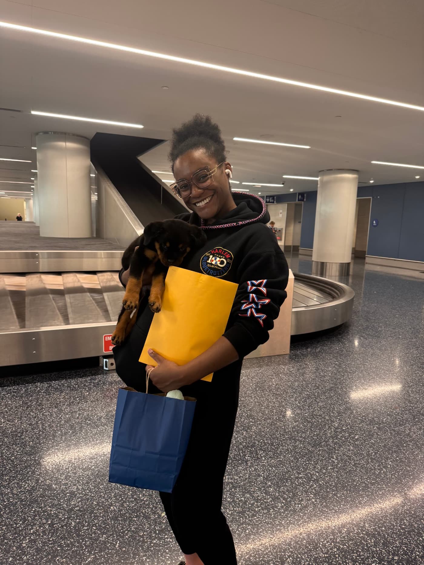 Apollo's owner holding her at the airport after bringing her home to Denver, Colorado — Lili's female puppy